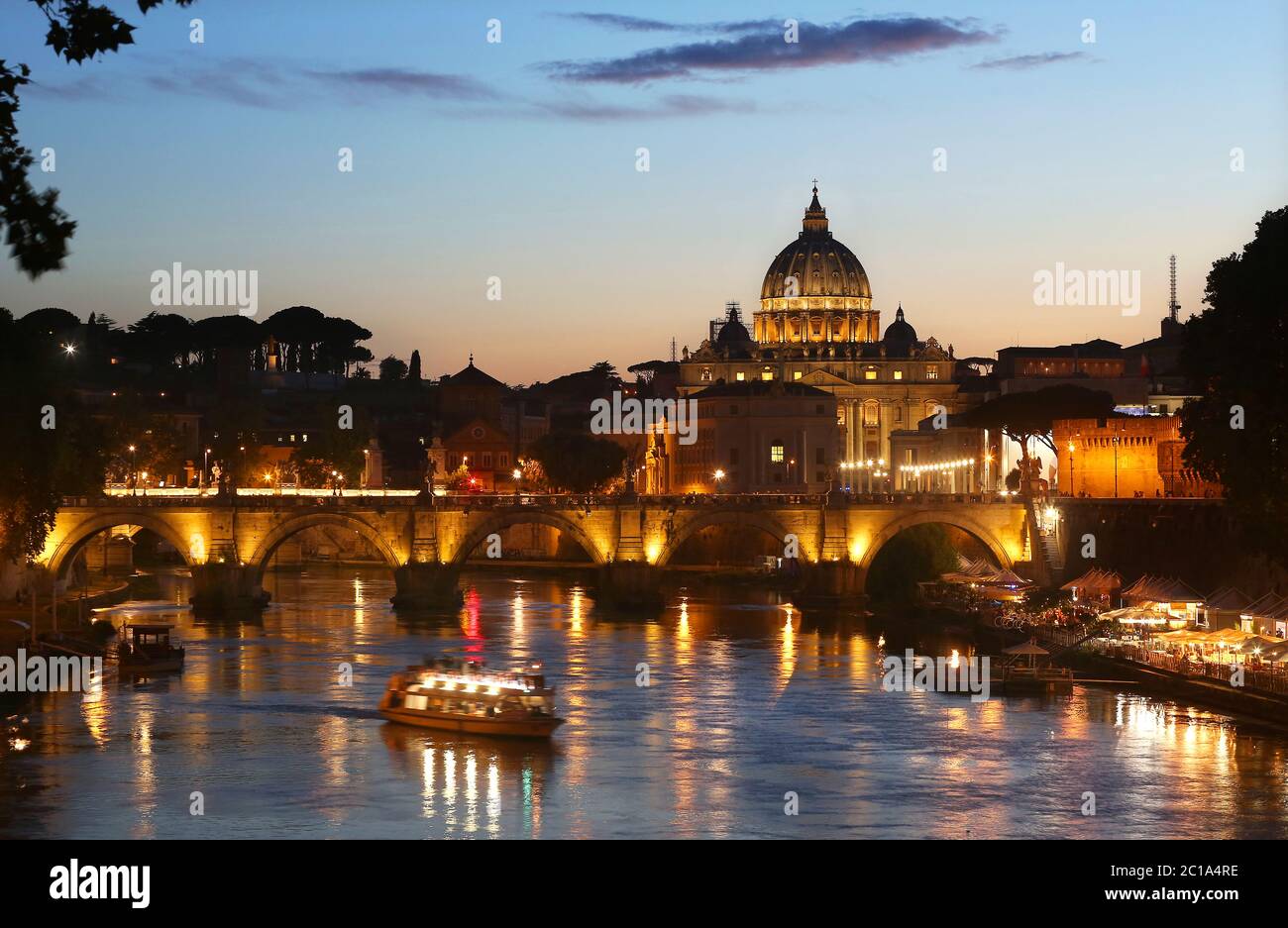 L'iconica Basilica di San Pietro e il Ponte Sant'Angelo al crepuscolo a Roma, Italia. Foto Stock