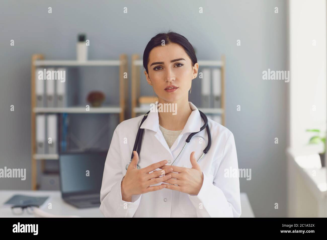 Dottore femminile che effettua una videochiamata online al suo paziente dalla clinica. Foto Stock