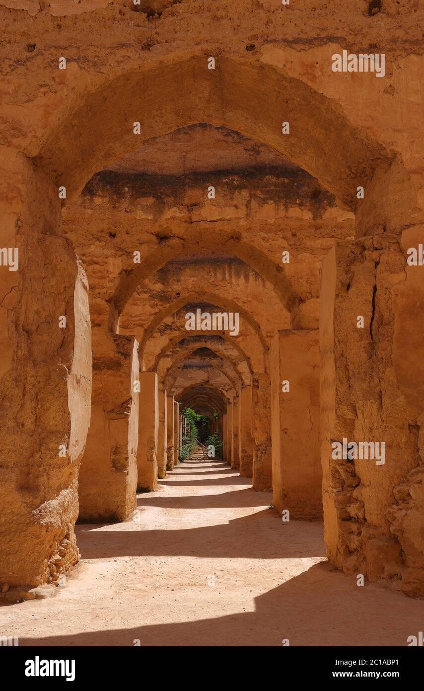 Gli archi medievali in rovina delle massicce scuderie reali di Heri es-Souani e dei granai di Moulay Ismail nella città imperiale di Meknes, Marocco. Foto Stock