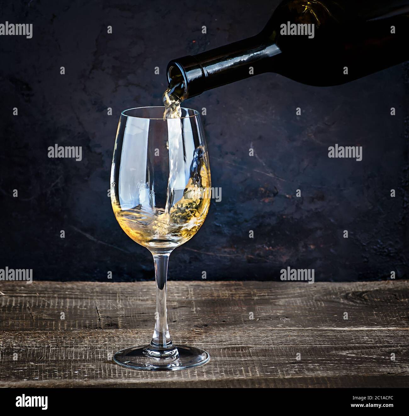 Versare il vino bianco da bottiglia Foto Stock