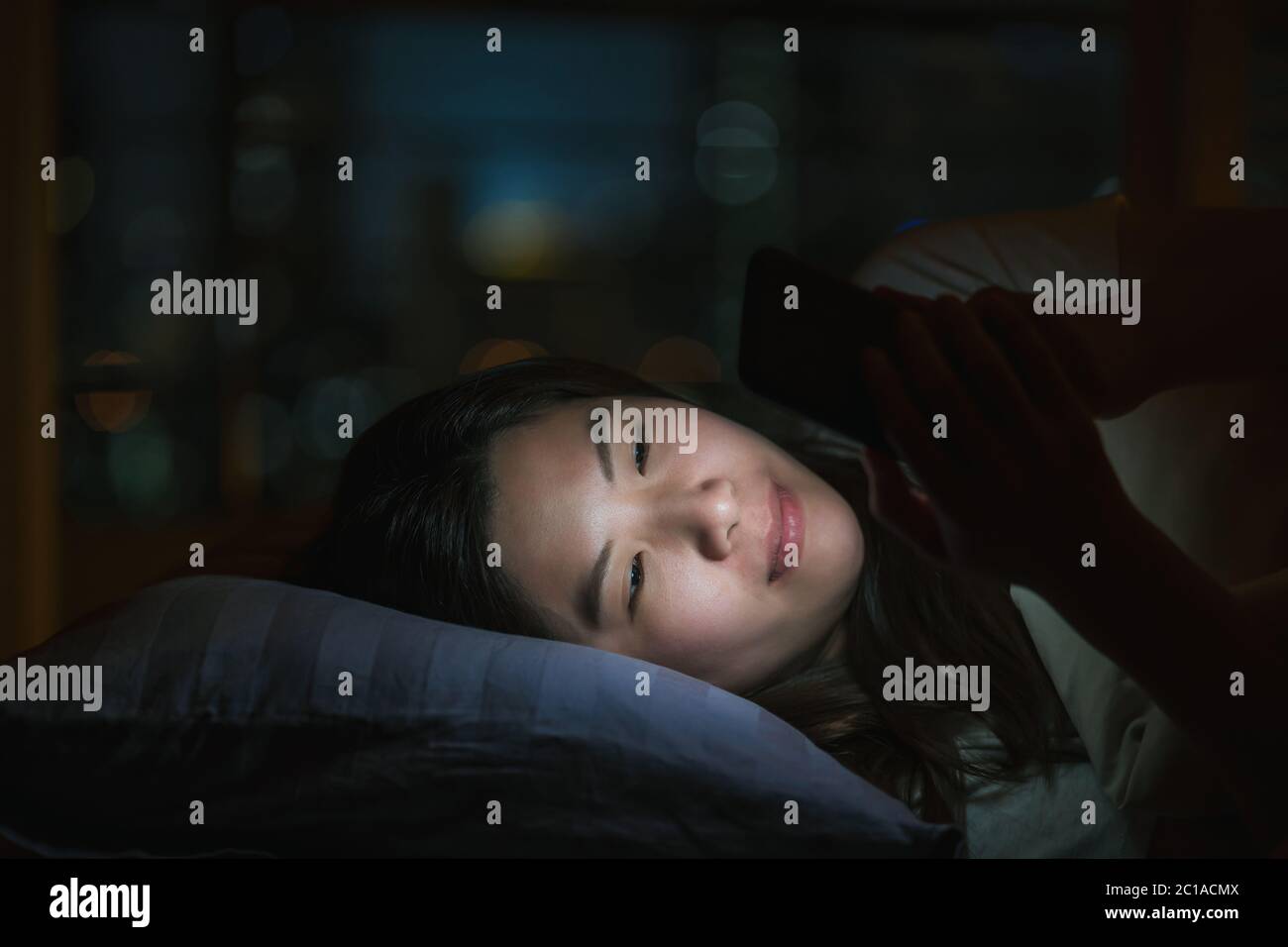 Donna asiatica che dorme e utilizza smartphone per social network o videoconferenza quando Covid19 focolaio, quarantena e panne di Coronavirus Foto Stock Donna asiatica che dorme e utilizza smartphone per social network o videoconferenza quando Covid19 focolaio, quarantena e panne di Coronavirus Foto Stock