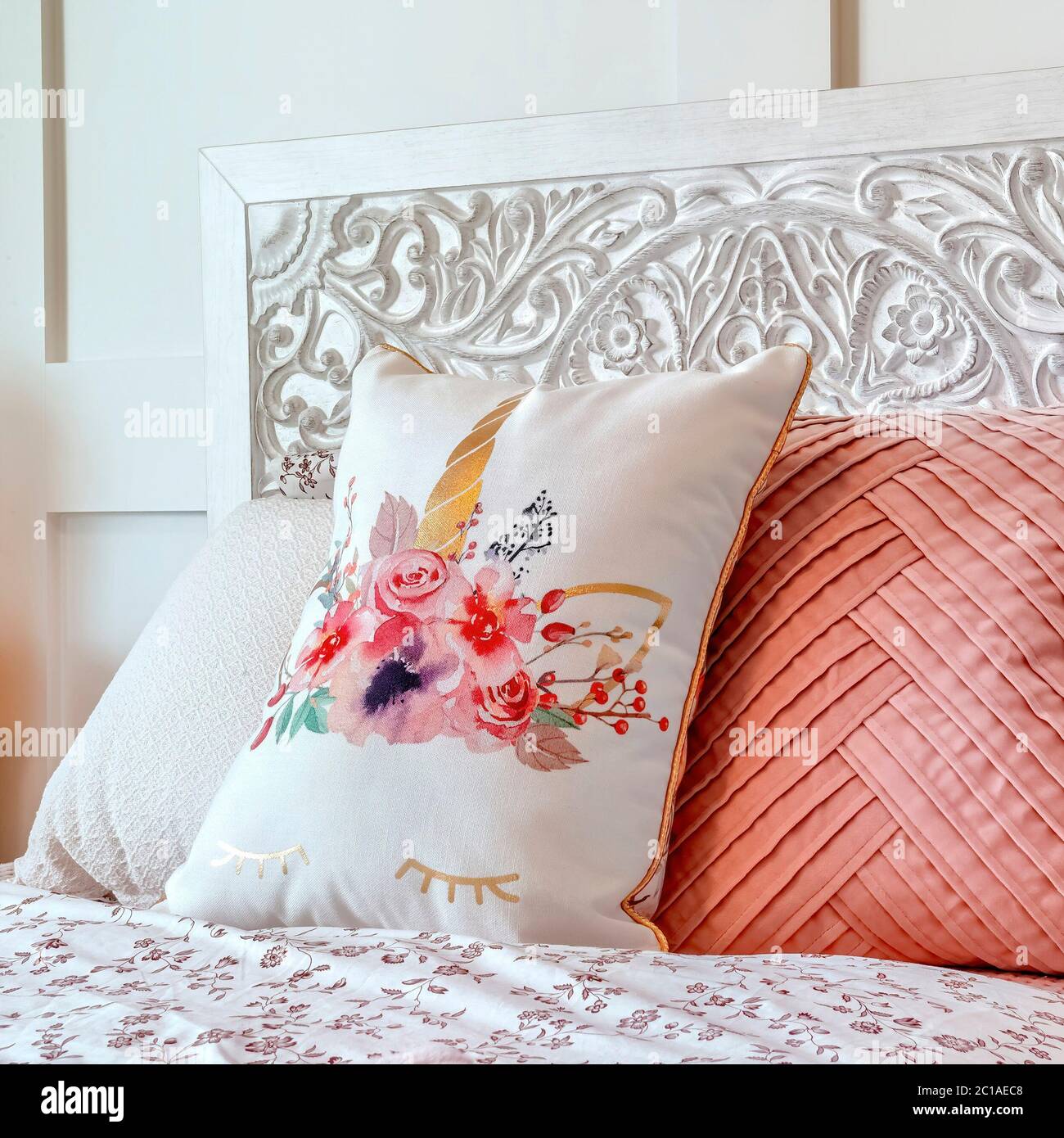 Cuscini quadrati soffici contro la testata decorativa di letto singolo  contro parete rivestita Foto stock - Alamy