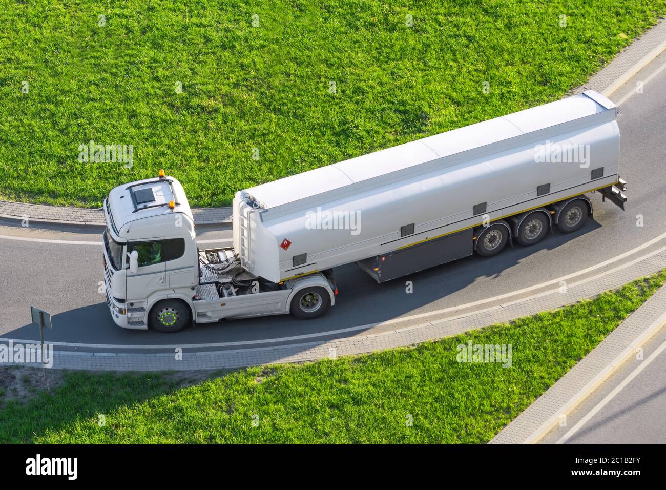 Il potente dumper bianco pesante con serbatoio per liquidi infiammabili gira sulla strada, vista ravvicinata Foto Stock