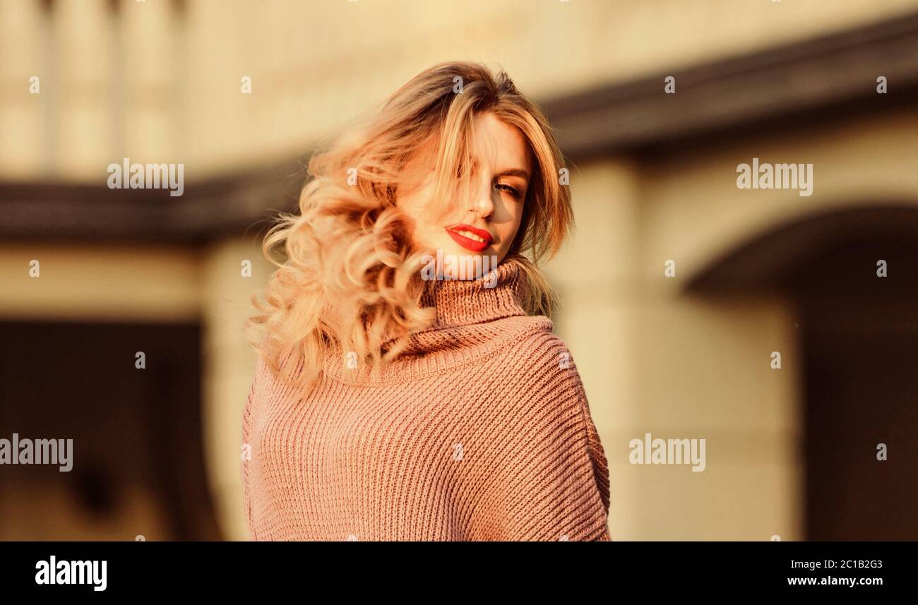Goditi la morbidezza. La ragazza bionda si fa faccia in vestito di caduta.  Concetto di maglieria. Modello Vogue. Maglione in lana di cashmere.  Pullover caldi e grandi. Donna indossare maglione. Felpa allungata