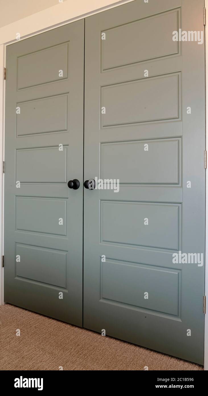 Chiusura verticale di porte doppie con pannelli e manopole di porte nere  opache Foto stock - Alamy