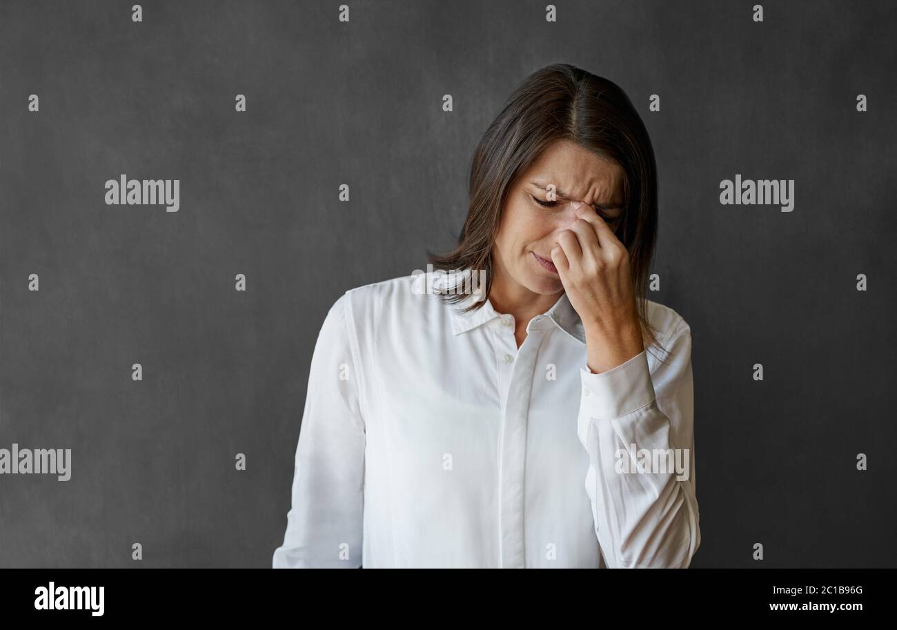 Donna d'affari che guarda stressata mentre si trova di fronte ad una lavagna Foto Stock