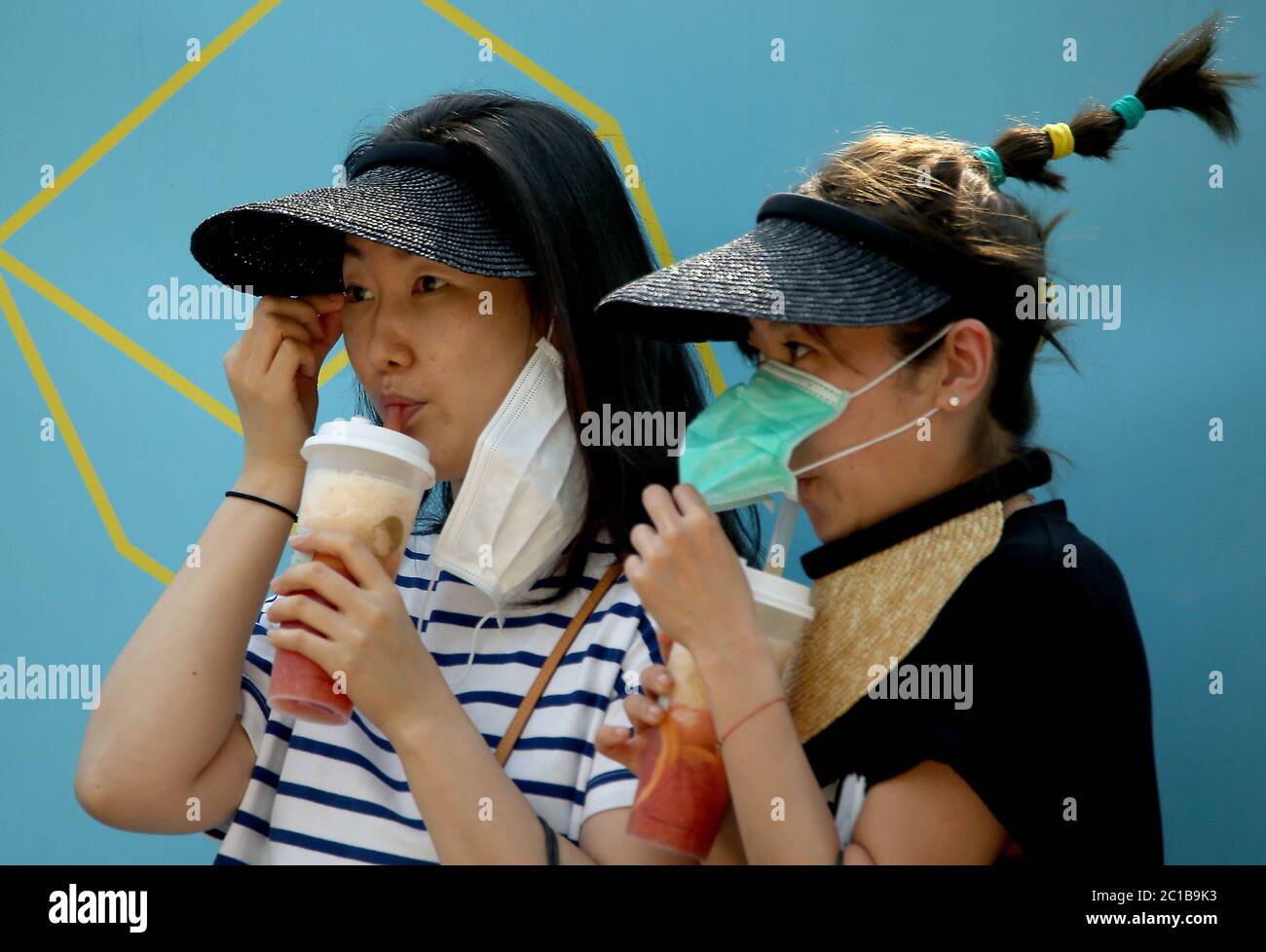 Pechino, Cina. 15 giugno 2020. Le donne cinesi indossano maschere protettive mentre camminano attraverso il centro di Pechino lunedì 15 giugno 2020. Tutti i luoghi di sport e intrattenimento al coperto sono stati chiusi nella capitale cinese, mentre il governo ha corso per contenere un'epidemia di coronavirus legata a un mercato alimentare all'ingrosso, con alcune parti della città sotto completa chiusura. Foto di Stephen Shaver/UPI Credit: UPI/Alamy Live News Foto Stock
