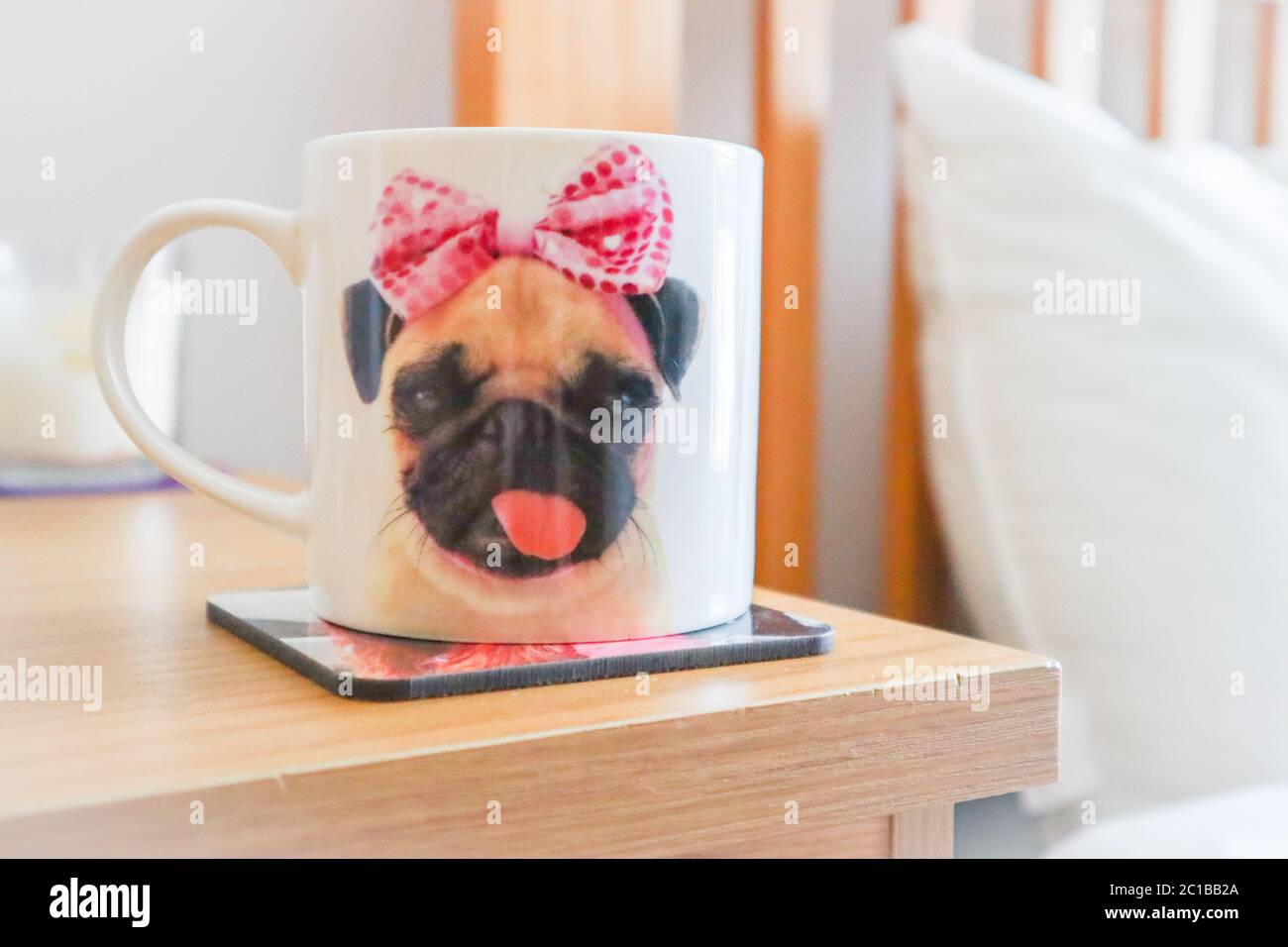 Tazza di caffè in carino cane tazza sul comodino in una camera da letto luminosa e ariosa Foto Stock