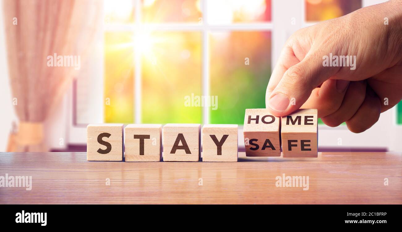 Stay Home - Quarantine Concept - Hand Turn blocchi di legno con messaggio di testo Foto Stock