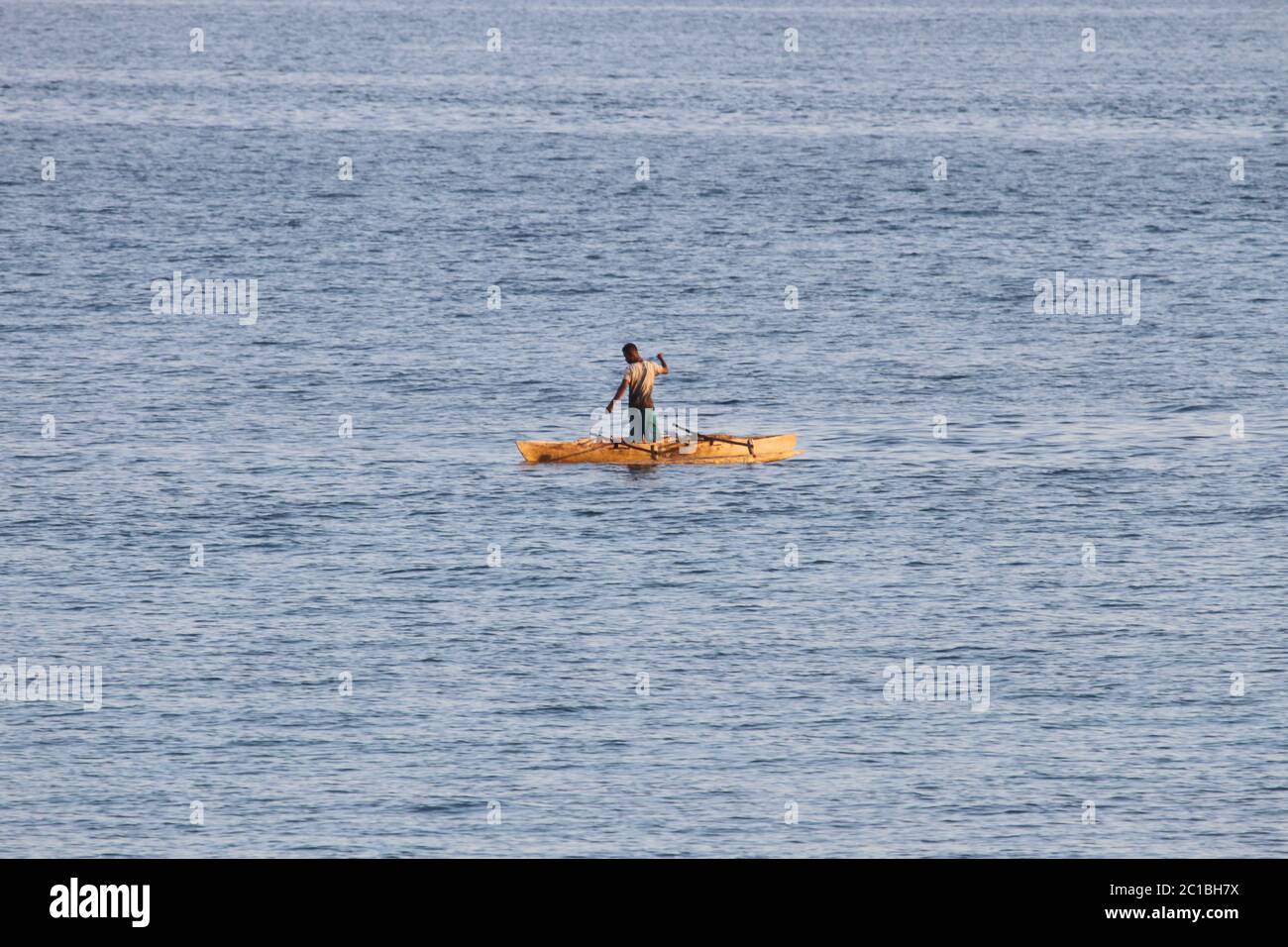 Pescatore in barca al largo della costa del villaggio di Ampangorinana, Isola di Nosy Komba, Madagascar. Foto Stock