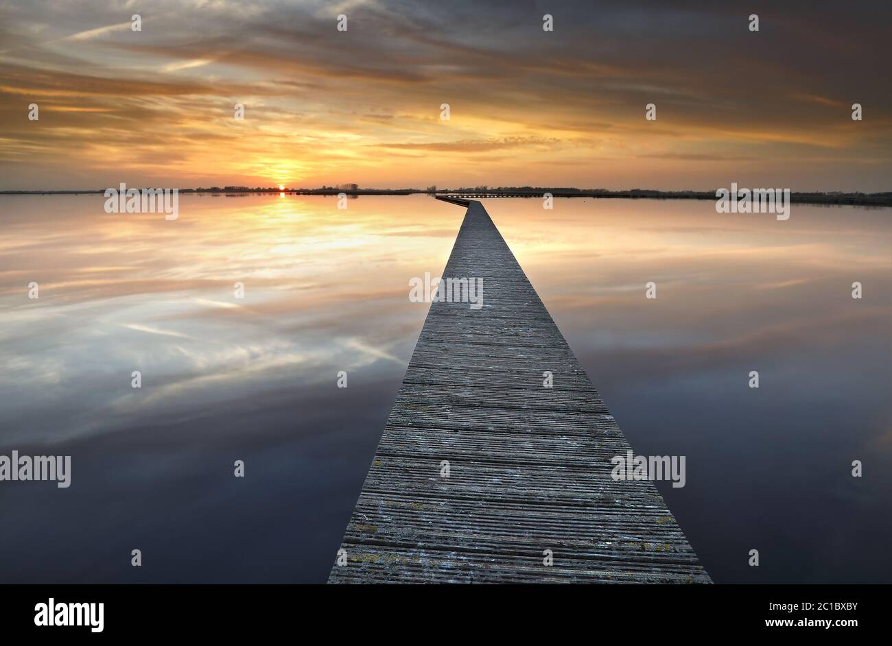 lungo passaggio pedonale sul grande lago al tramonto Foto Stock