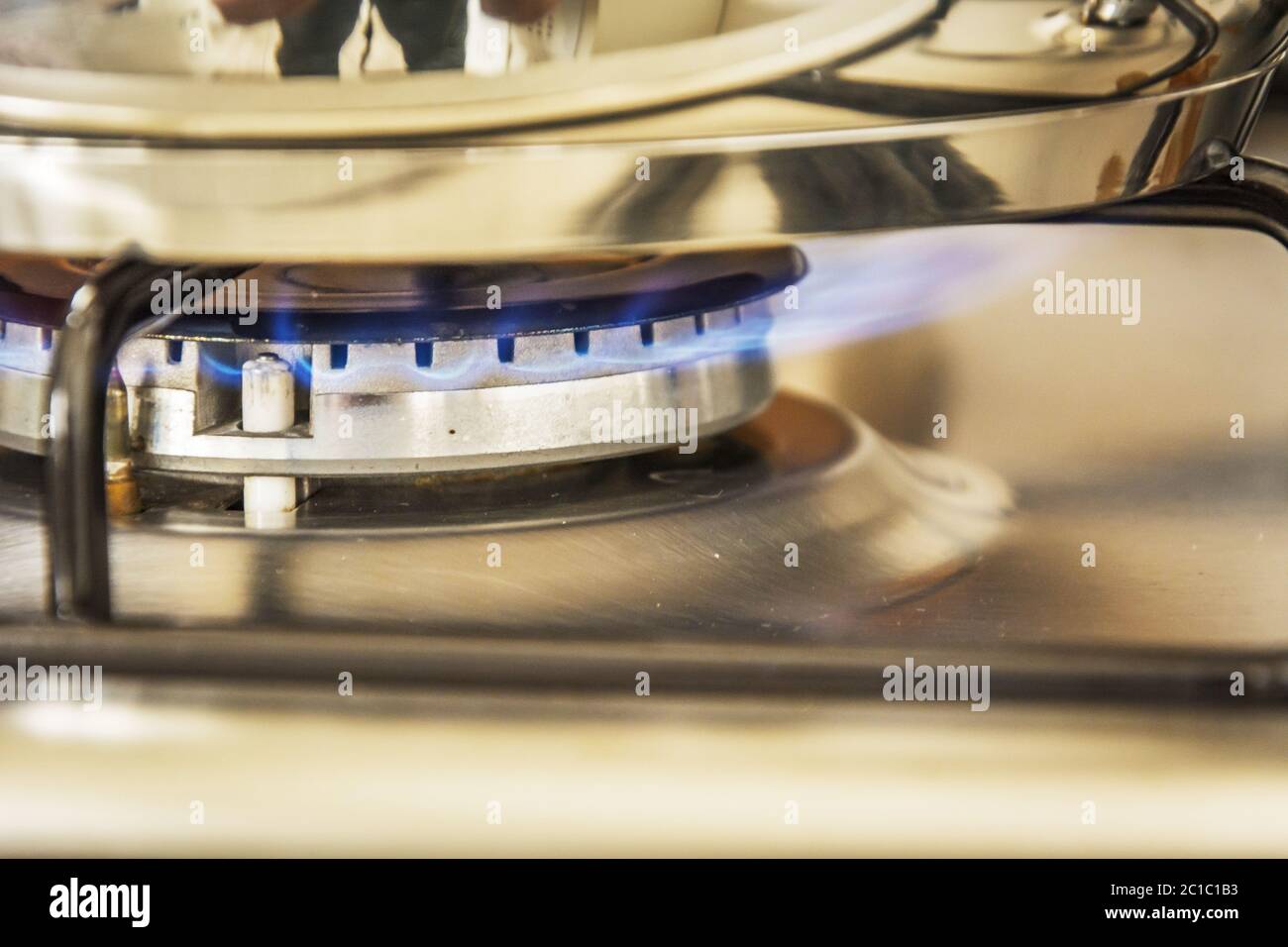 Fuoco di gas di fiamma blu su un pentola bollente del fornello a gas della cucina Foto Stock