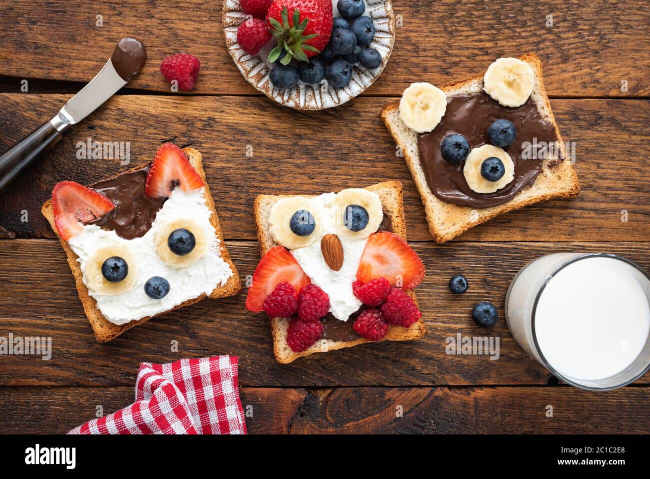 Colazione per bambini, divertenti toast su un tavolo di legno. Idee di arte alimentare per la colazione dei bambini o il menu del pranzo scolastico. Vista dall'alto Foto Stock