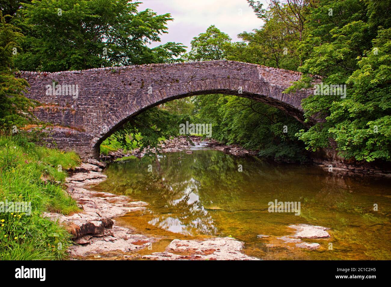 Il ponte a cavallo a Stainforth, appena sopra le cascate a livelli di Stainforth Force Foto Stock