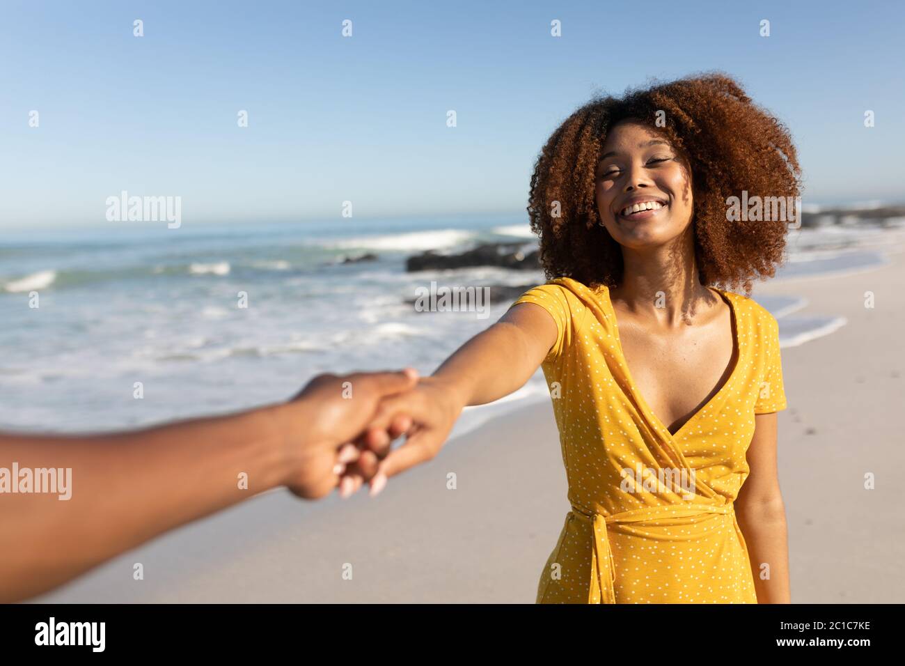 Donna da corsa mista sorridente sulla spiaggia Foto Stock