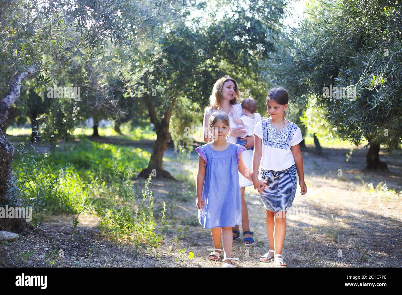 Madre e tre bambini in Oliveto Foto Stock