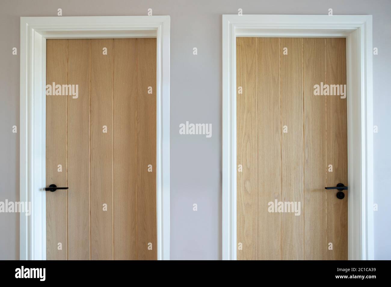 Primo piano di due porte di legno in Casa moderna simboleggiando la scelta Foto Stock