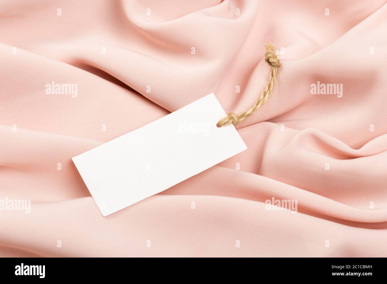 Etichetta rettangolare su un abbigliamento. Moda, persone e concetto di shopping - primo piano prezzo tag di abbigliamento Foto Stock