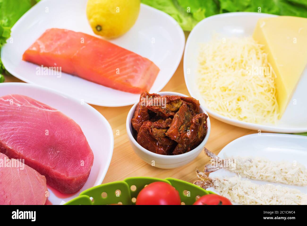 Filetto di tonno crudo appetitoso su un tavolo con un iarda di insalata greca con salmone e cetrioli di limone e pomodori, nonché la chee Foto Stock