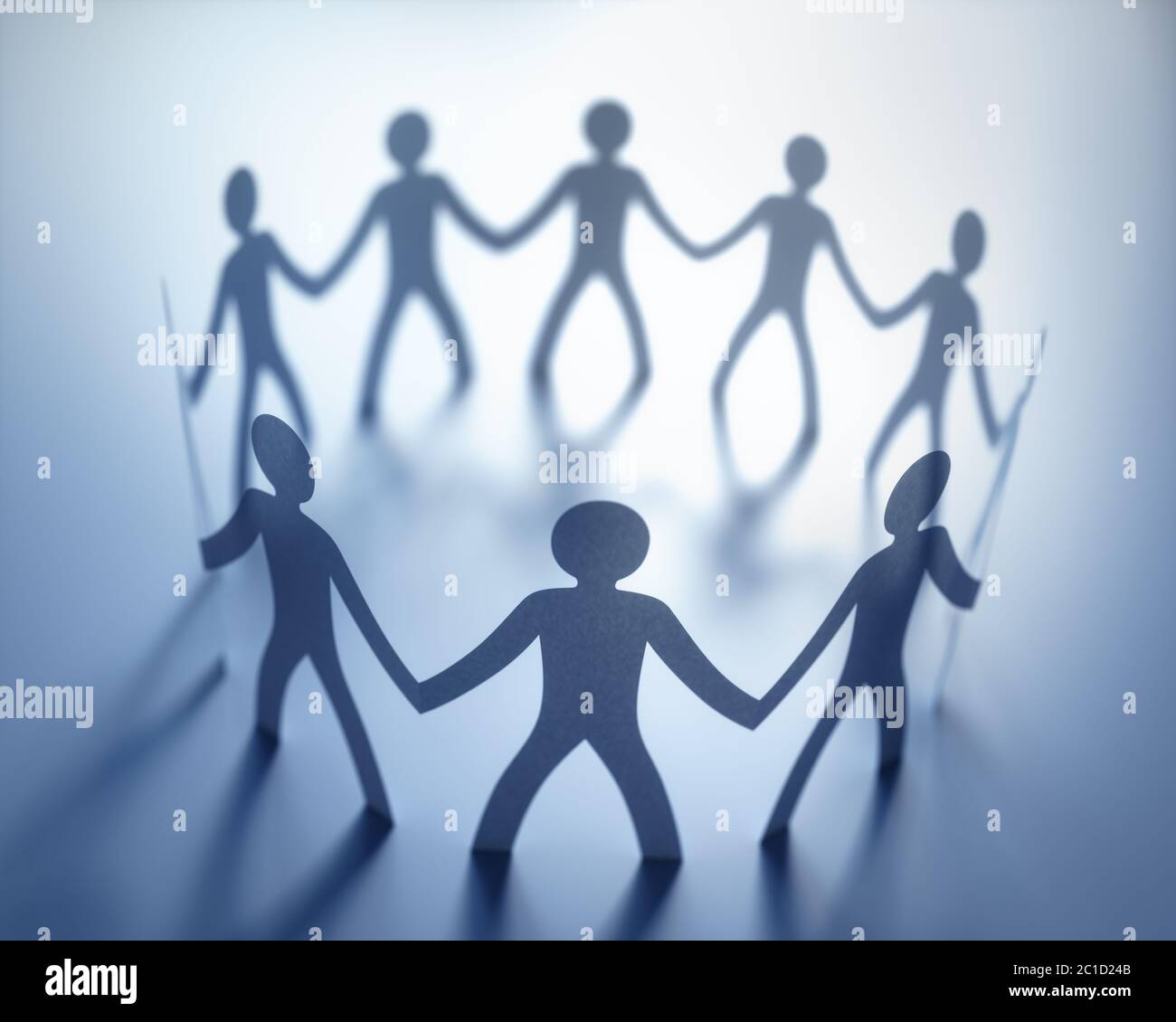 Gruppo di persone, unite nella riunione di un'organizzazione. Carta tagliata a forma di persone. Foto Stock