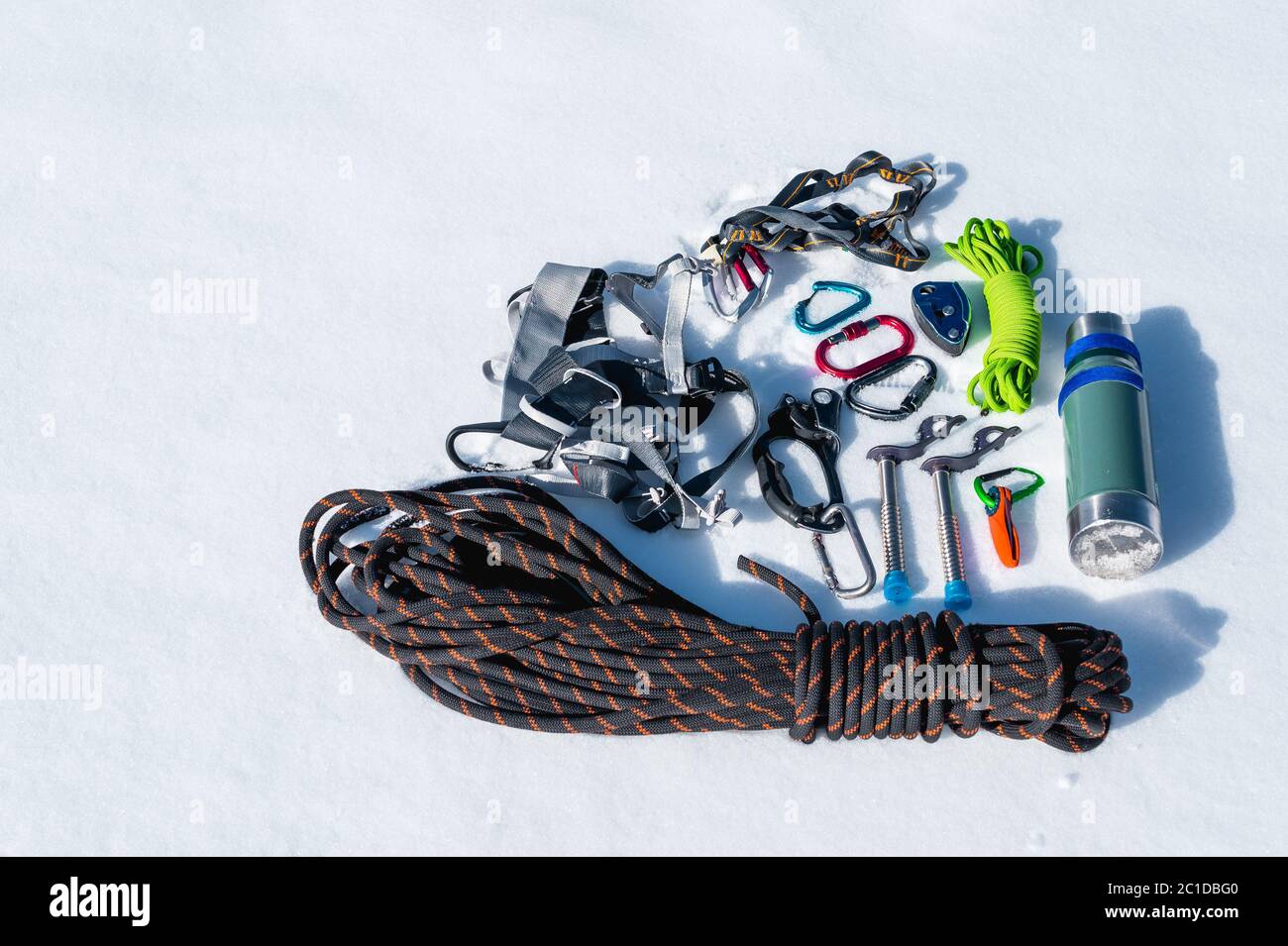 Primo piano di attrezzatura invernale per l'arrampicata su neve fresca in una giornata di sole. Carbini con gazebo di corda e zhumar così come altri adap Foto Stock