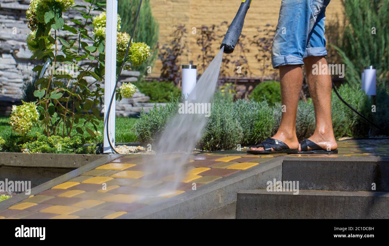 Uomo di lavaggio percorso concreto con la rondella di pressione Foto Stock