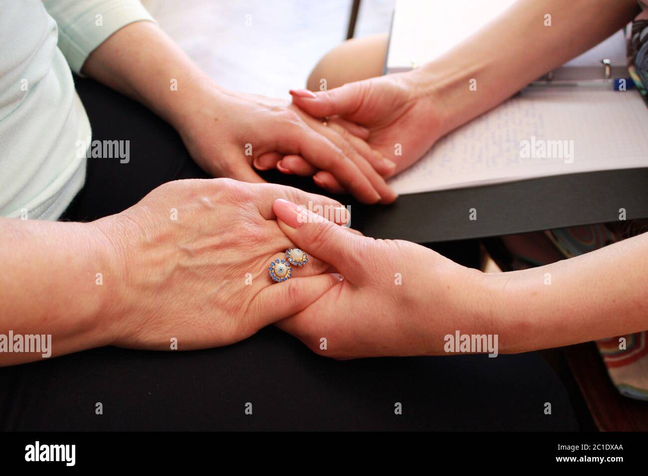 Due ragazze tengono le mani l'una dell'altra durante un corso di formazione. Due ragazze tengono le mani su un corso sull'insegnamento delle tecniche esoteriche. fr Foto Stock