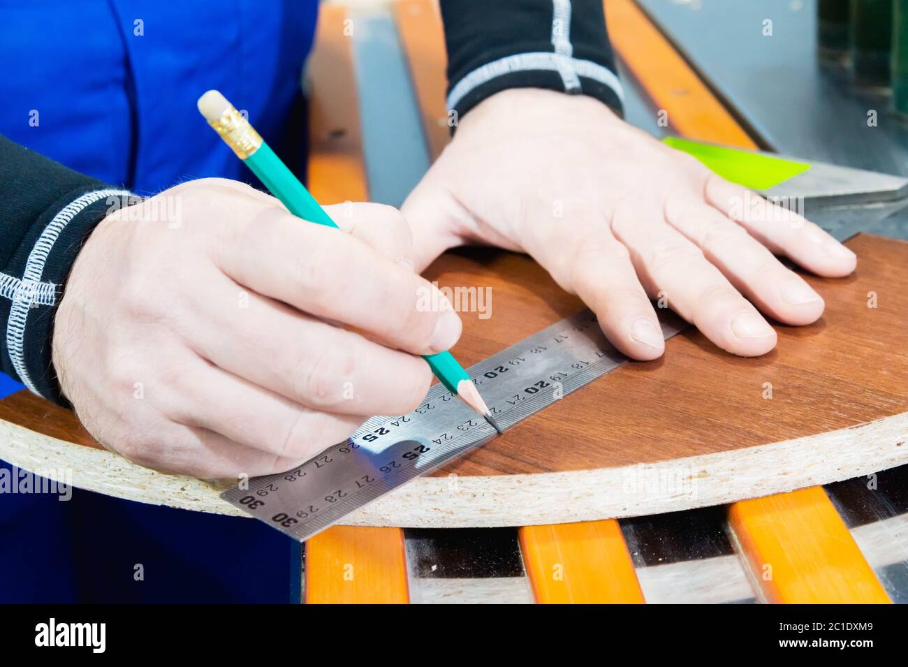 Un primo piano della mano del maestro del falegname è contrassegnato da un righello e da una matita vuota. Il concetto di mobili manuali Foto Stock