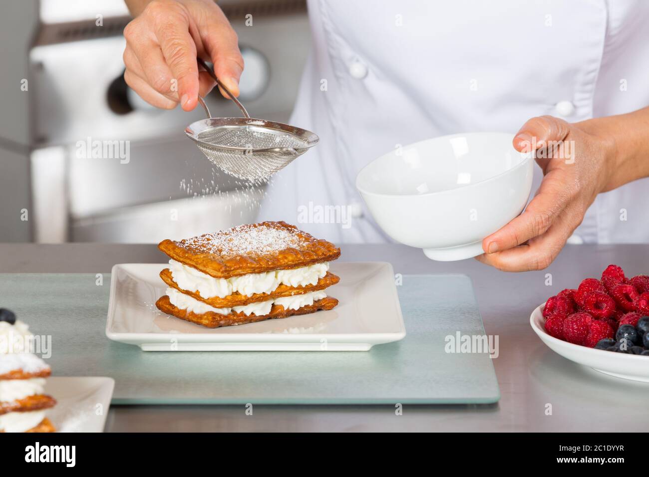 Chef pasticcere decorare con la glassa di zucchero pasticceria a torta Foto Stock