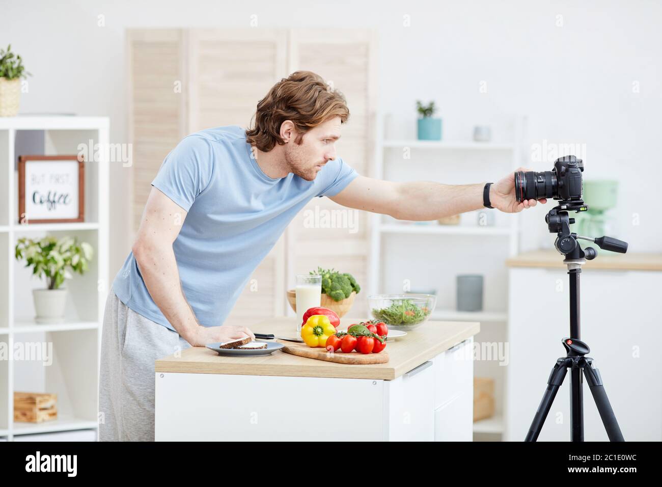 Giovane blogger impostare la macchina fotografica e prepararsi per la comunicazione online sta andando cucinare un pasto sano Foto Stock