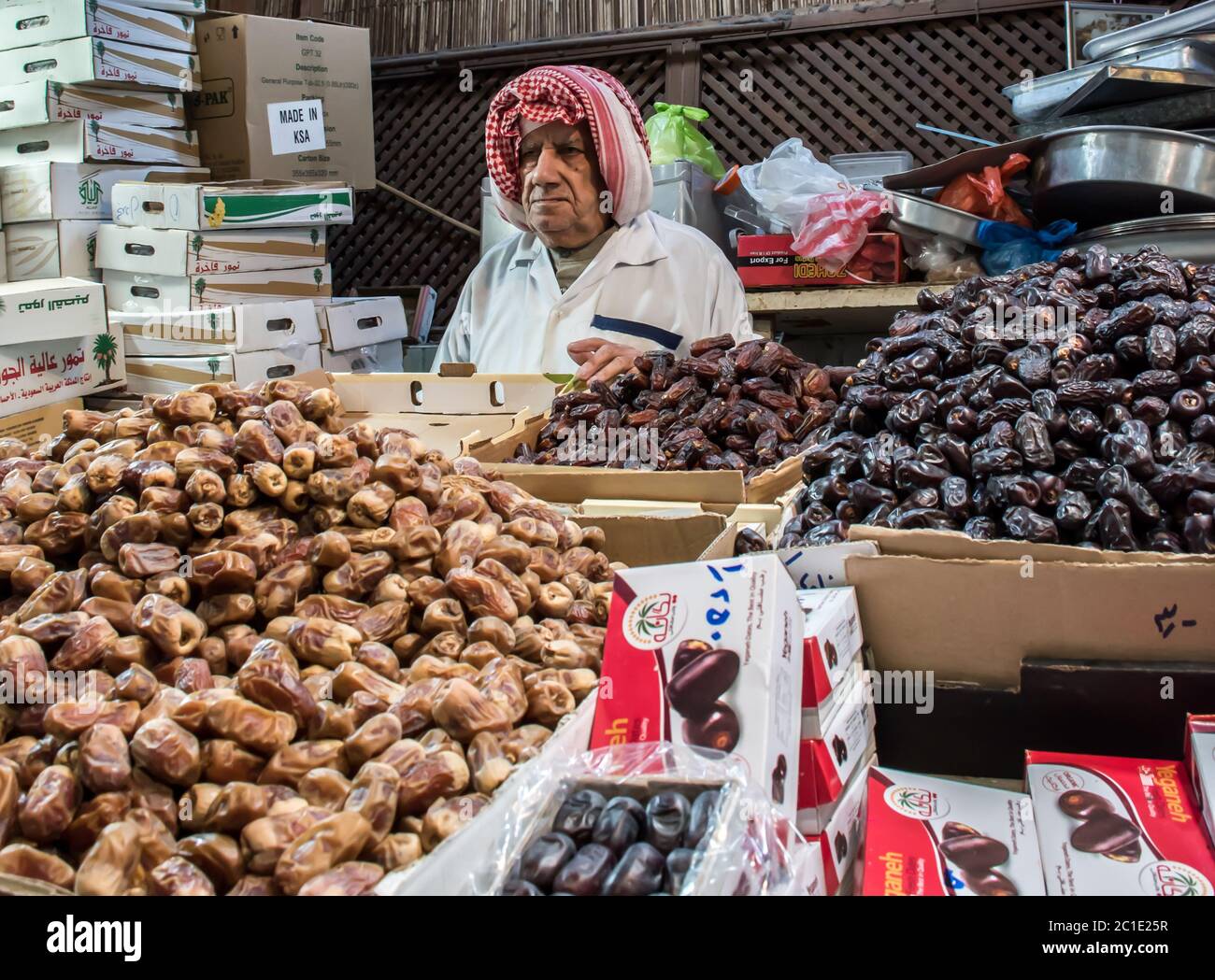 Uomo anziano iraniano che vende le date fresche e secche come un posto di vendita del fornitore di strada o negozio nel souk Mubarakiya, Kuwait. Foto Stock