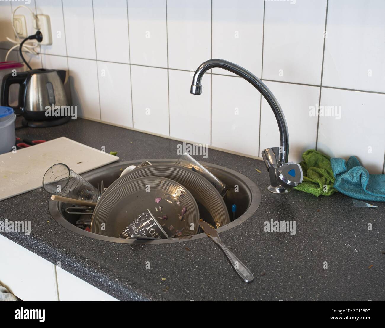 Un sacco di piatti sporchi nel bianco lavello in cucina Foto Stock