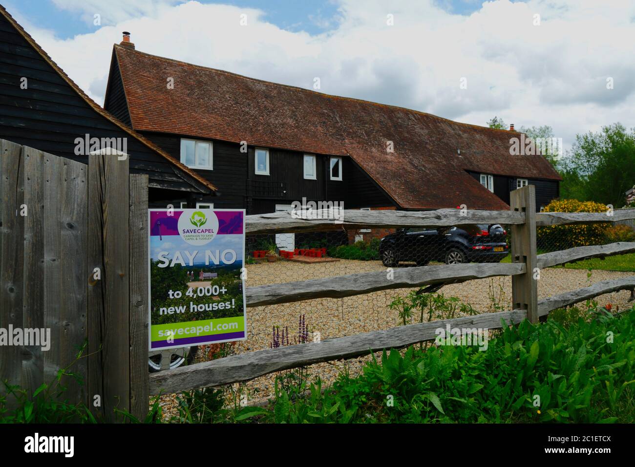 Salva Capel campagna poster nel villaggio di Tudeley protestando contro il piano di Tunbridge Wells Borough Consiglio per costruire oltre 4.000 case a Tudeley e Capel nei prossimi anni in un 'villaggio giardino' sviluppo. Gli abitanti del luogo dicono che il progetto, che si trova sulla terra designata Green Belt, è di gran lunga superiore a quello che la parrocchia rurale di Capel e le sue infrastrutture possono affrontare. L'area si trova anche ai margini della Medway Valley e in una zona alluvione ad alto rischio. Sono previsti anche nuovi e grandi sviluppi di abitazioni per i vicini Five Oak Green e Paddock Wood. Kent, Inghilterra Foto Stock