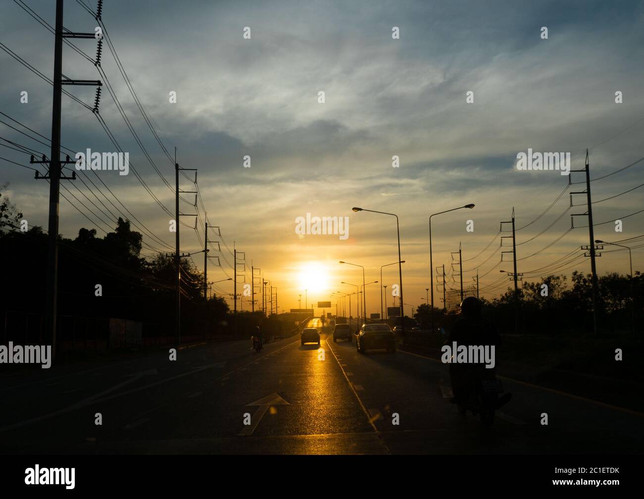 Strada di sera, andando dritto verso il sole. Silhouette vista strada. Tramonto alla fine della strada. Foto Stock