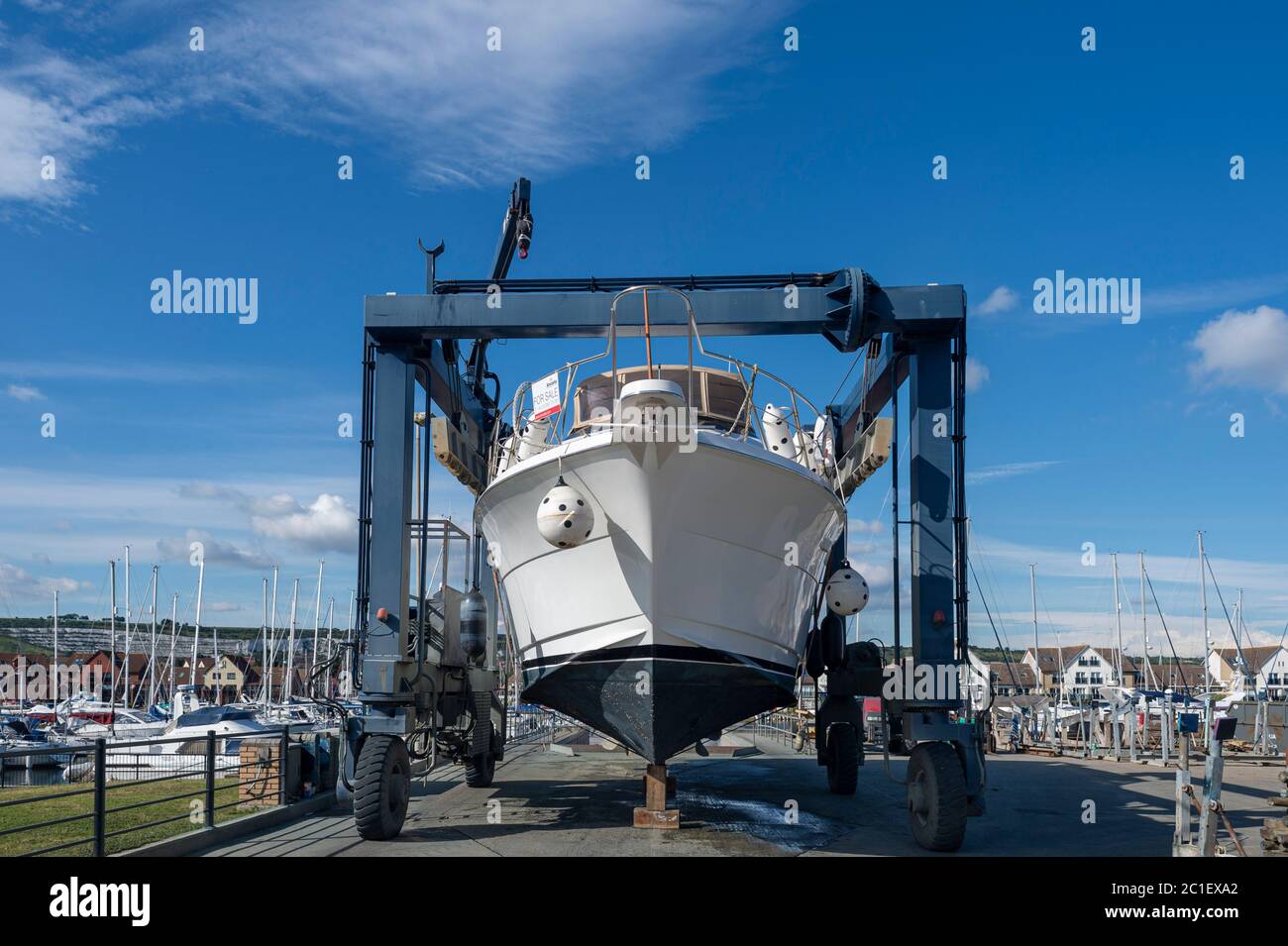 Grande yacht a motore di lusso in un paranco per barche, che viene sollevato fuori dall'acqua. Foto Stock