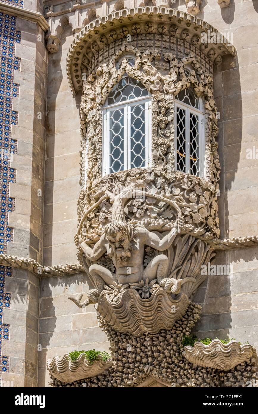 Finestra decorata con grottesche gargoyle su una facciata del Palacio da Pena Foto Stock