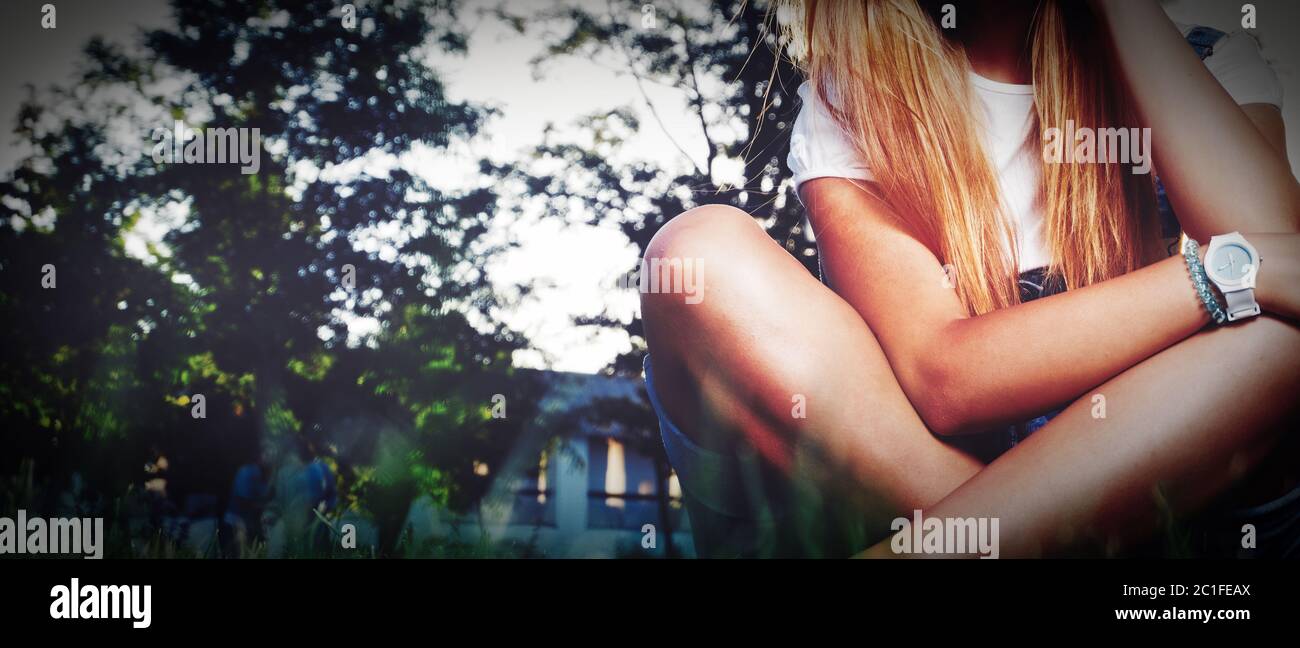 Ragazza nel parco che riposa croce zampe sull'erba, sparato con copyspace, vista occhio verme Foto Stock