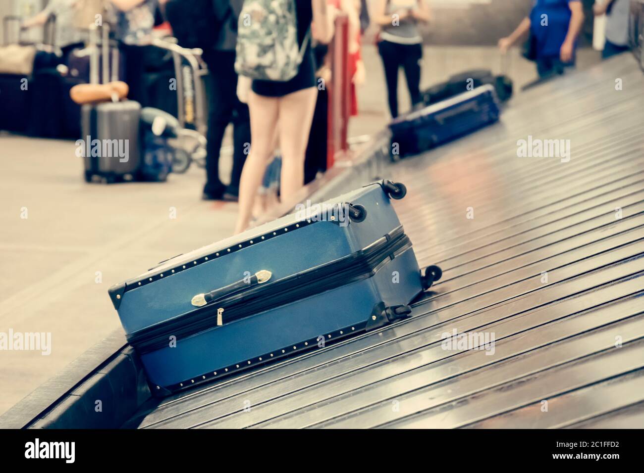 Valigia sul nastro trasportatore bagagli nell'area ritiro bagagli presso il terminal dell'aeroporto Foto Stock