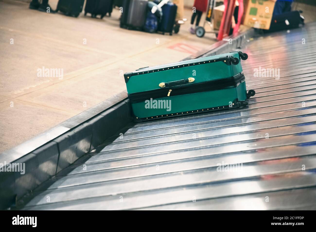 Valigia sul nastro trasportatore bagagli nell'area ritiro bagagli presso il terminal dell'aeroporto Foto Stock