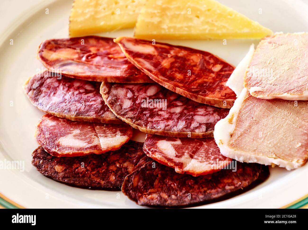 Una selezione tipica di salumi iberico comprende prosciutto (Jamon), lombo di maiale (lomo), salsiccia rossa spagnola (chorizo) e salchichÃ³n. Foto Stock