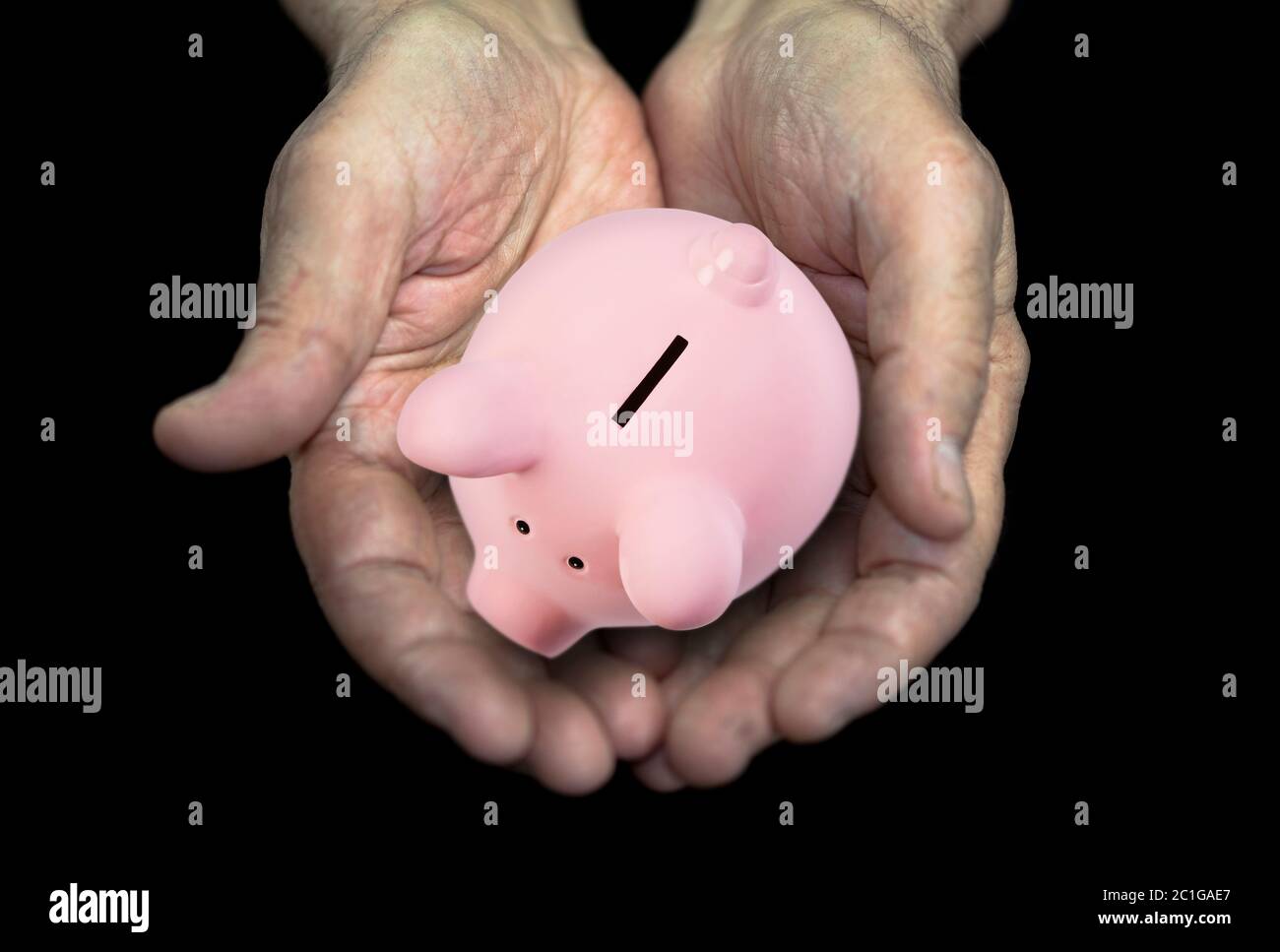 Vecchie mani con salvadanaio, concetto di pensione Foto Stock