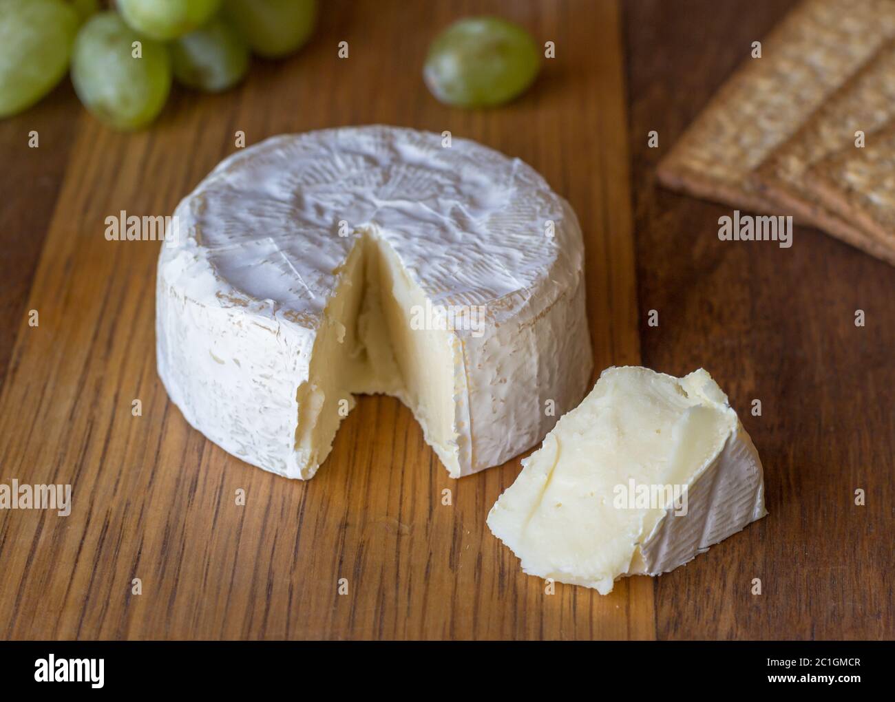 Formaggio Camembert e cuneo su tavola di legno Foto Stock