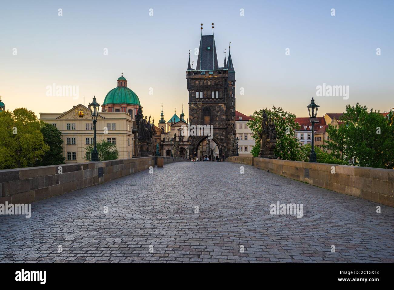 Alba a Praga con la vecchia torre del ponte della città di Praga, in ceco Foto Stock