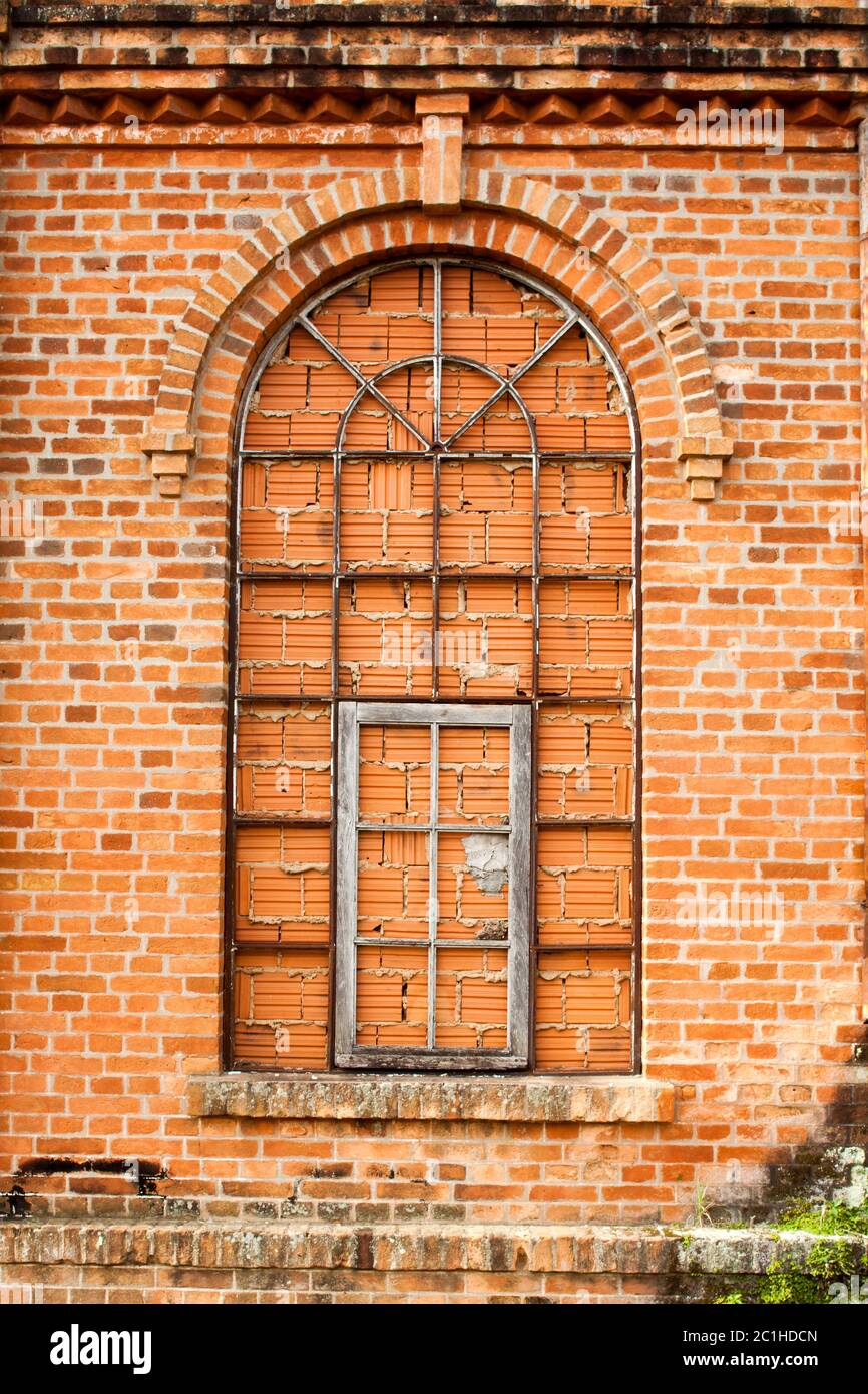 Finestre chiuse in vecchio muro di mattoni arancioni Foto Stock