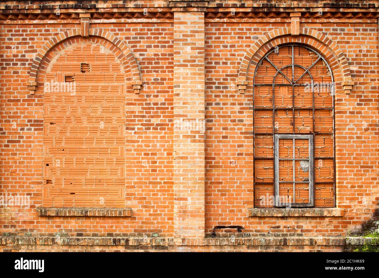 Finestre chiuse in vecchio muro di mattoni arancioni Foto Stock