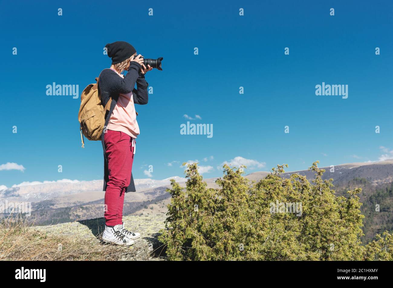 Natura fotografo scattare foto sulla sua fotocamera dslr all'aperto durante il viaggio escursionistico sul Caucaso. Caucaso settentrionale Russia Foto Stock