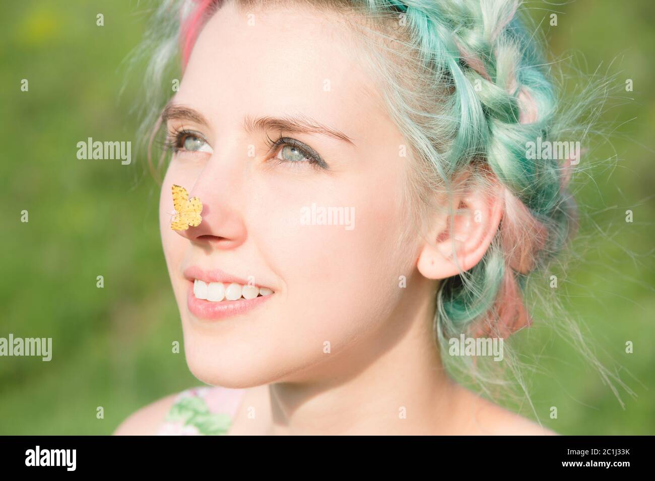Farfalla gialla seduta sul naso cute giovane ragazza sulla natura. Armonia e godimento in natura Foto Stock