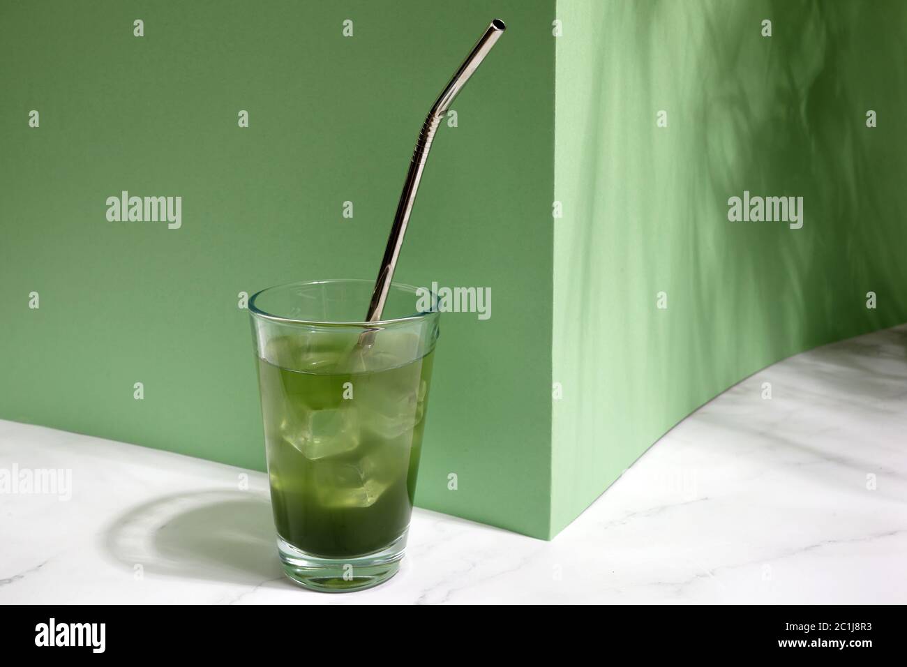 Bevanda fredda fresca verde con ghiaccio su sfondo verde Foto Stock