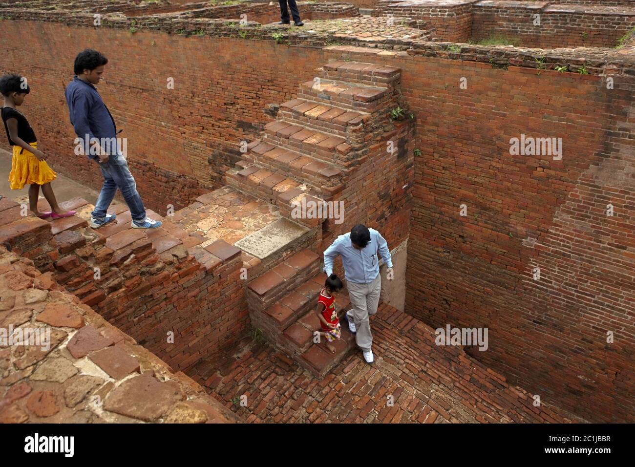 Famiglia che scende da uno dei monasteri scavati all'interno dell'antico complesso universitario buddista di Nalanda a Nalanda, Bihar, India. Foto Stock