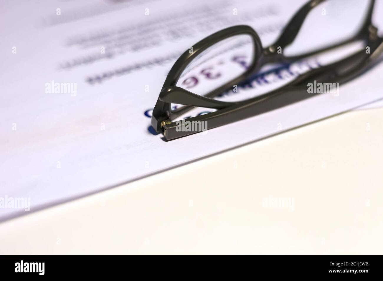 Occhiali neri su un foglio di carta bianco Foto Stock